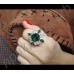 Превосходное кольцо в виде цветка с зелеными камнями в белой позолоте